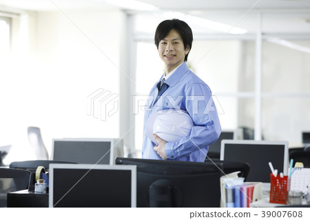 Young businessman standing in office Young businessman standing in office 39007608