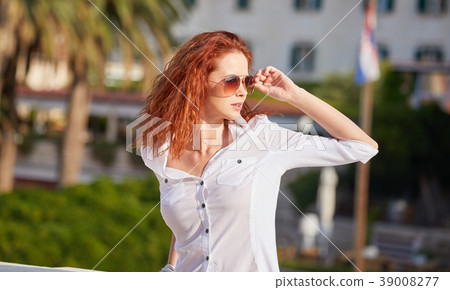 Portrait of an adorable brown-eyed girl with her hand up, combin 39008277