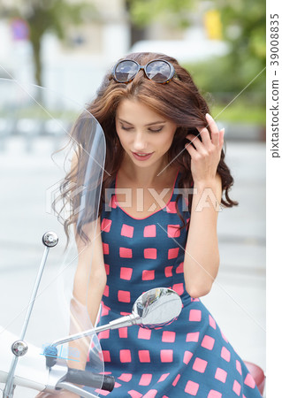 Young beautiful italian woman sitting on a italian scooter. 39008835