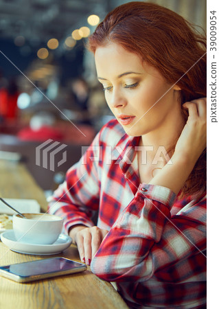 Red haired woman reading book  in cafe. City break  concept 39009054