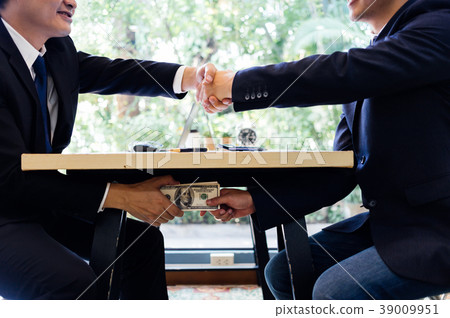 Hands passing money under table corruption bribery Hands passing money under table corruption bribery 39009951