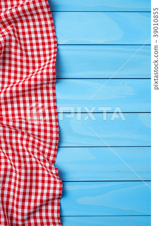 Red folded tablecloth over blue wooden table 39010855