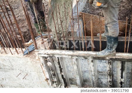 Pouring concrete into the construction of the 39011790