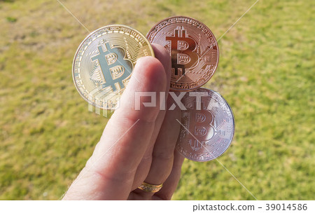 Cryptocurrency coins in a hand, Bitcoin Cryptocurrency coins in a hand, Bitcoin 39014586