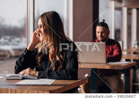 Happy businesswoman sitting at the table and 39026607