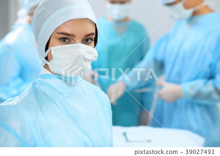 Medical team in masks performing operation. Focus 39027491