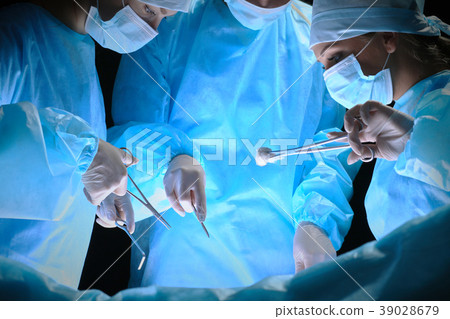 Group of surgeons at work in operating theater 39028679