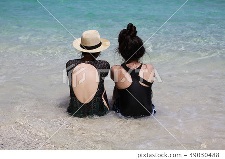 Portrait two young women ocean friendship sitting Portrait two young women ocean friendship sitting 39030488
