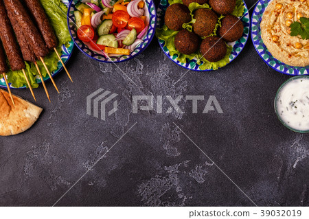 Classic kebabs, falafel and hummus on the plates. Classic kebabs, falafel and hummus on the plates. 39032019