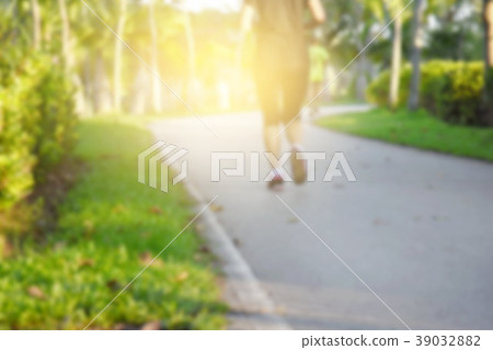 Blur female running through  in a park on road.  39032882