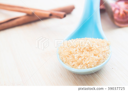 Close up brown sugar in spoon on wooden table Close up brown sugar in spoon on wooden table 39037725