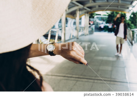 A girl is checking time from her wristwatch  A girl is checking time from her wristwatch  39038614