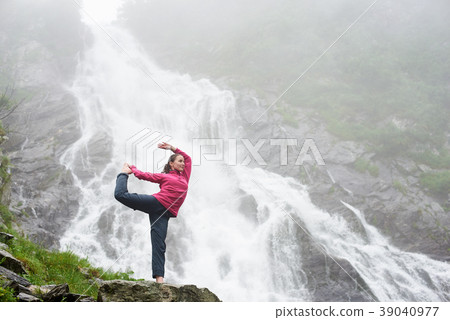 Sporty girl posing under waterfall Balea in Fagarash mountains Sporty girl posing under waterfall Balea in Fagarash mountains 39040977