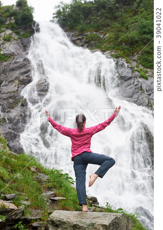 Female tourist observing beautiful waterfall in the mountains Female tourist observing beautiful waterfall in the mountains 39041022