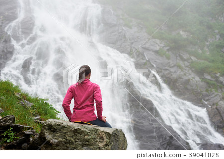 Female tourist observing beautiful waterfall in the mountains Female tourist observing beautiful waterfall in the mountains 39041028