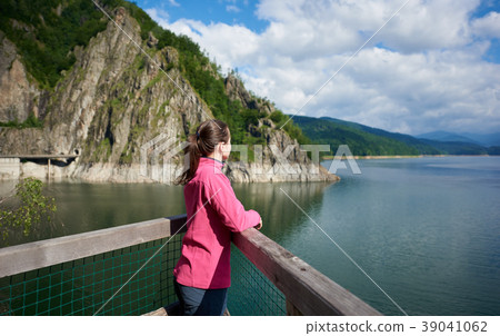 female tourist admiring view of mountains and lake female tourist admiring view of mountains and lake 39041062