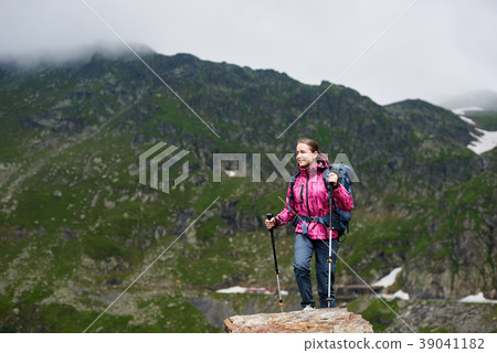 Smiling hiker woman climbing green rocky mountains Smiling hiker woman climbing green rocky mountains 39041182