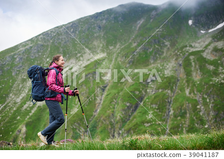 Woman backpacker with trekking sticks hiking in mountains of Romania 39041187