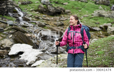woman with backpack and trekking stick in mountain woman with backpack and trekking stick in mountain 39041474