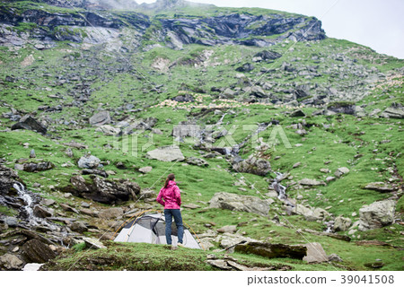 Woman on rocky slope enjoying view hills Woman on rocky slope enjoying view hills 39041508