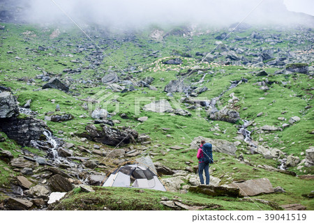 tourist near tent on rocky slope 39041519