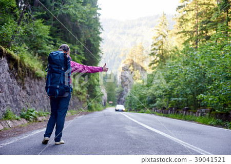 Girl with hitchhiking by the side of the road. Girl with hitchhiking by the side of the road. 39041521