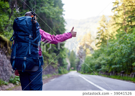 tourist hitchhiking on empty mountain road tourist hitchhiking on empty mountain road 39041526