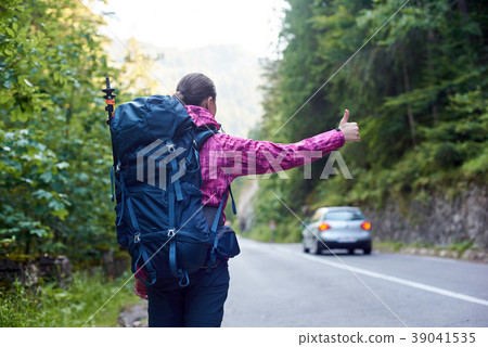 woman catching car on road in Bicaz Gorge woman catching car on road in Bicaz Gorge 39041535