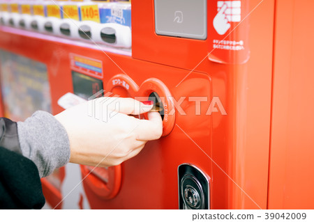 Woman hand inserting coin in vending machine. Woman hand inserting coin in vending machine. 39042009