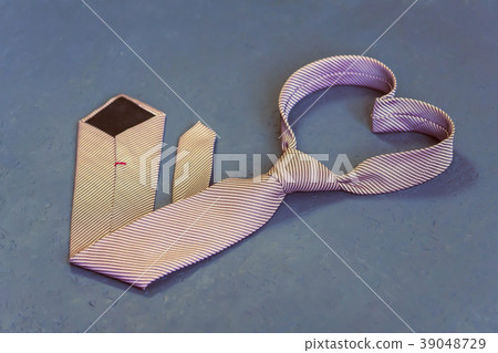 pink tie is tied in the shape of a heart on a gray pink tie is tied in the shape of a heart on a gray 39048729