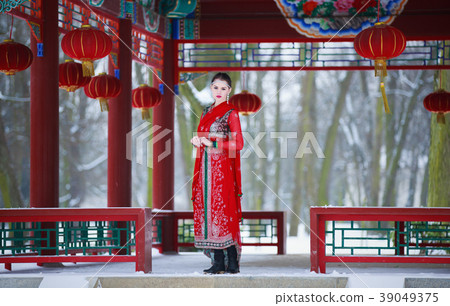 Woman in oriental dress in a winter park 39049375