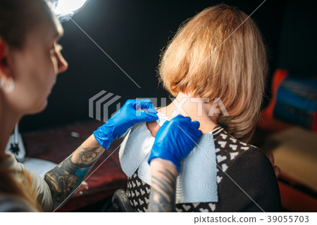 Tattoo artist prepares client skin for tattooing Tattoo artist prepares client skin for tattooing 39055703