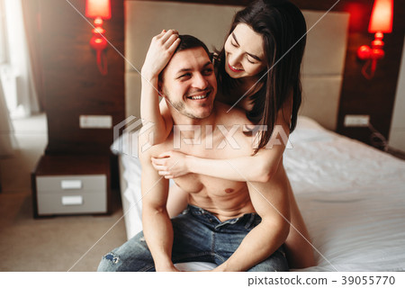 Happy love couple hugging on big white bed Happy love couple hugging on big white bed 39055770