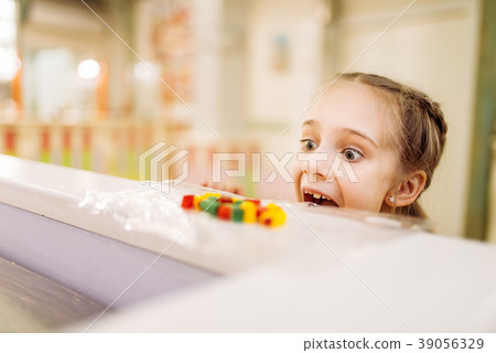 Petty thief takes sweet from table in candy store Petty thief takes sweet from table in candy store 39056329