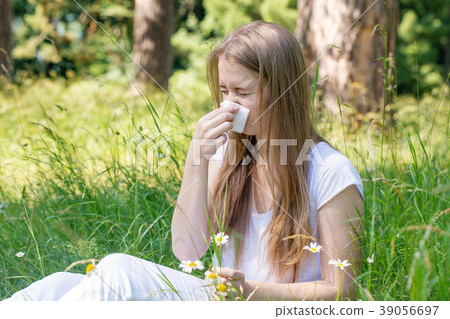 Woman in the meadow sneezes Woman in the meadow sneezes 39056697