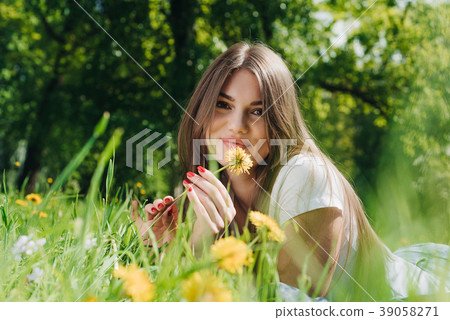 Woman laying on grass in park Woman laying on grass in park 39058271