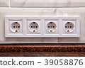 Electrical sockets on a kitchen tile wall 39058876