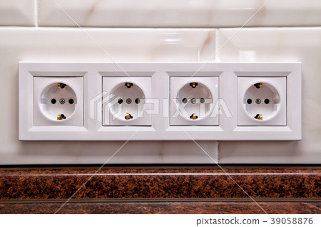 Electrical sockets on a kitchen tile wall Electrical sockets on a kitchen tile wall 39058876