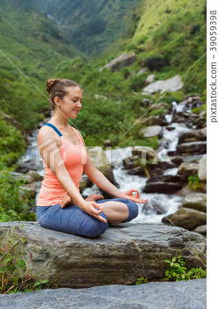 Woman in Padmasana outdoors Woman in Padmasana outdoors 39059398