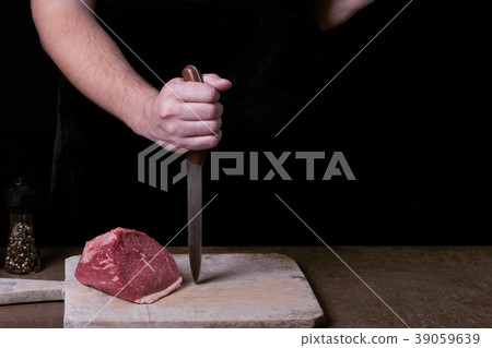Butcher preparing to cutt raw beaf meat on kitchen 39059639