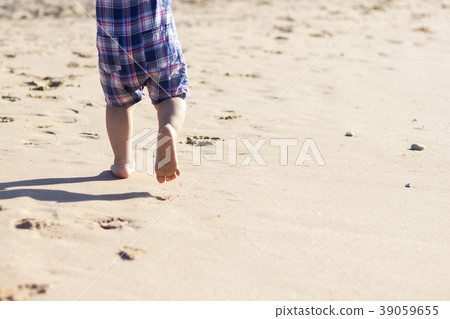 Legs of children stand on the beach. Baby feet in 39059655