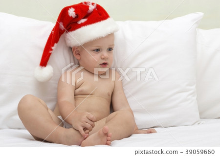 Picture of cute baby wearing santa hat while lying 39059660