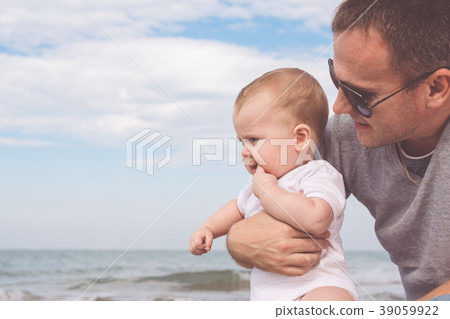 Father and son playing on the beach at the day time. Father and son playing on the beach at the day time. 39059922