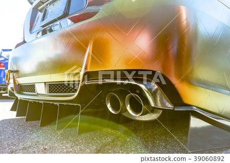 Orange car with dual exhaust pipes on concrete 39060892