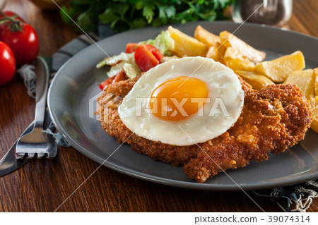 Breaded viennese schnitzel with fried agg 39074314