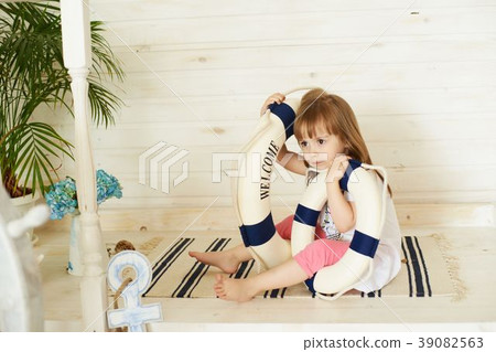 Little girl waiting with blue lifebuoy Little girl waiting with blue lifebuoy 39082563