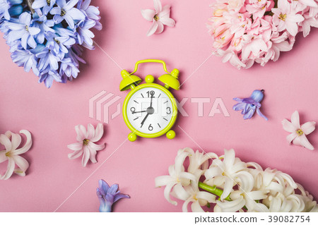 Spring flowers pink flat lay. Alarm clock 39082754