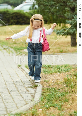 Young girl walk on curb. Jeans, ping bag 39083300