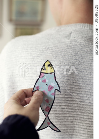 paper fish in the back of man for april fools day 39098529