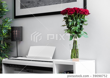 Bouquet of  red Roses standing on the white piano 39098752